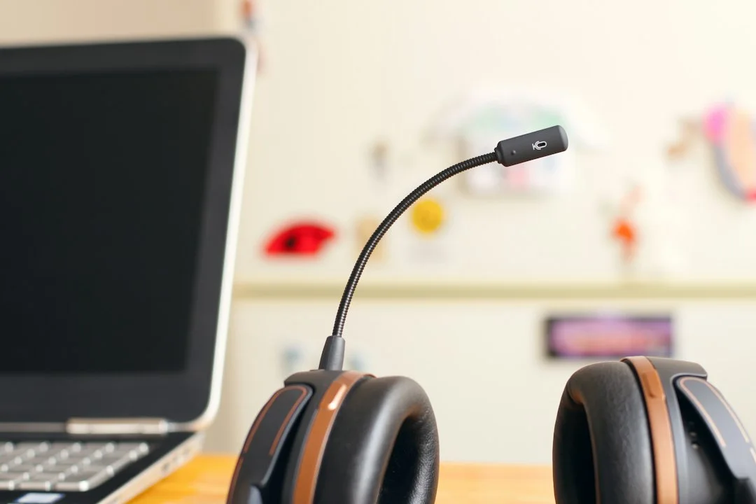 A headset beside a laptop for remote communication.