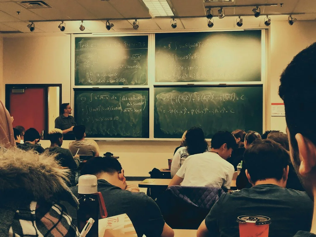 Students facing a lecturer in a classroom.