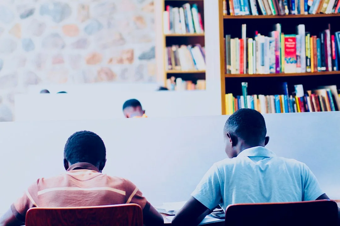 Learners studying among library bookshelves.