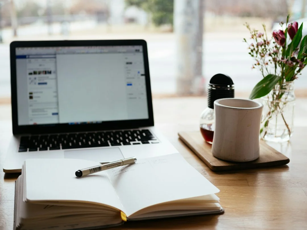 Notebook and laptop arranged on a desk.