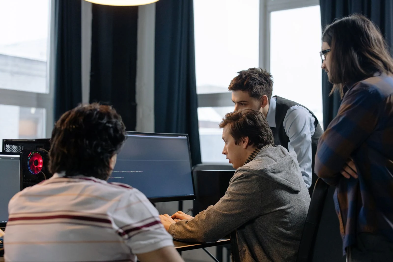 Stock photograph of software colleagues working at computers in an office.