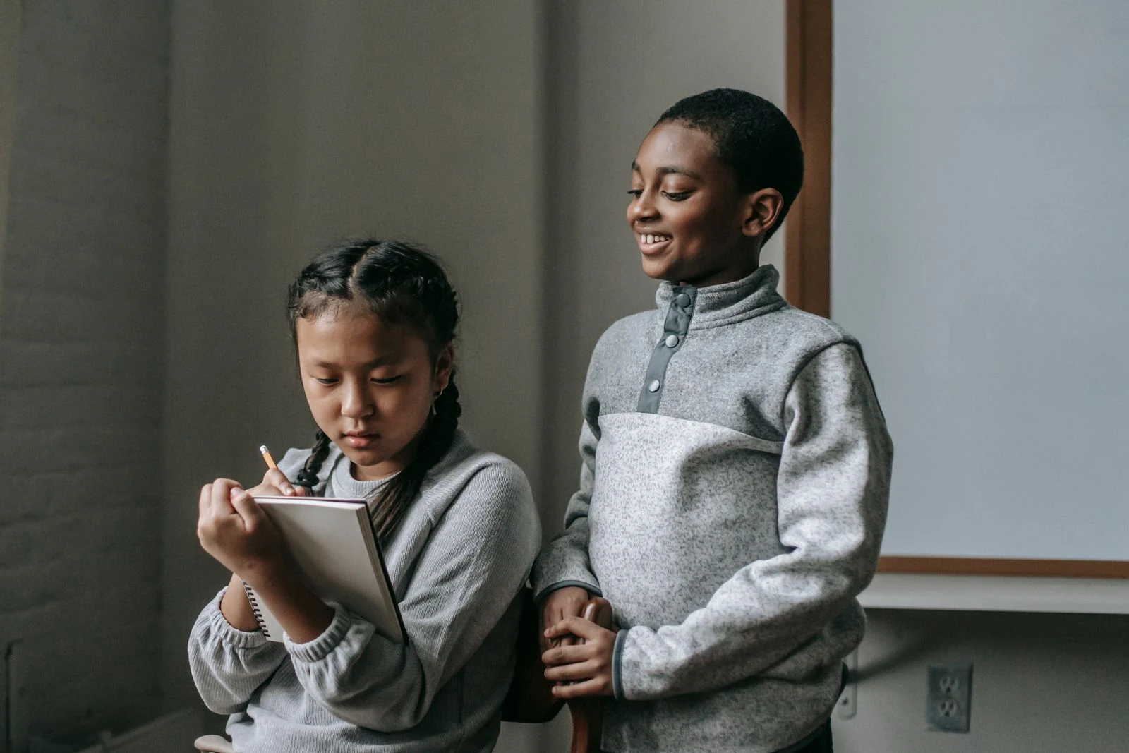 American English for Children — Stock photograph of two children learning together with a tablet in a classroom.